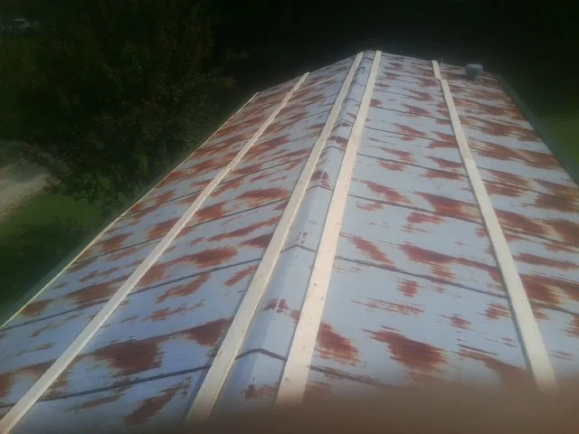 Rusted metal roof panels with new wood purlins before replacement — Storm Damage Roof Repair in Counce by Roofing Brothers