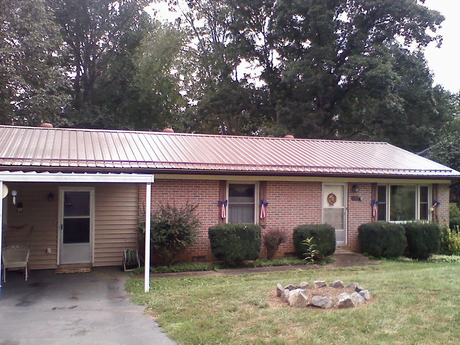 Bronze metal roof and carport on a brick ranch home — Roof Repair work by our crew in Counce